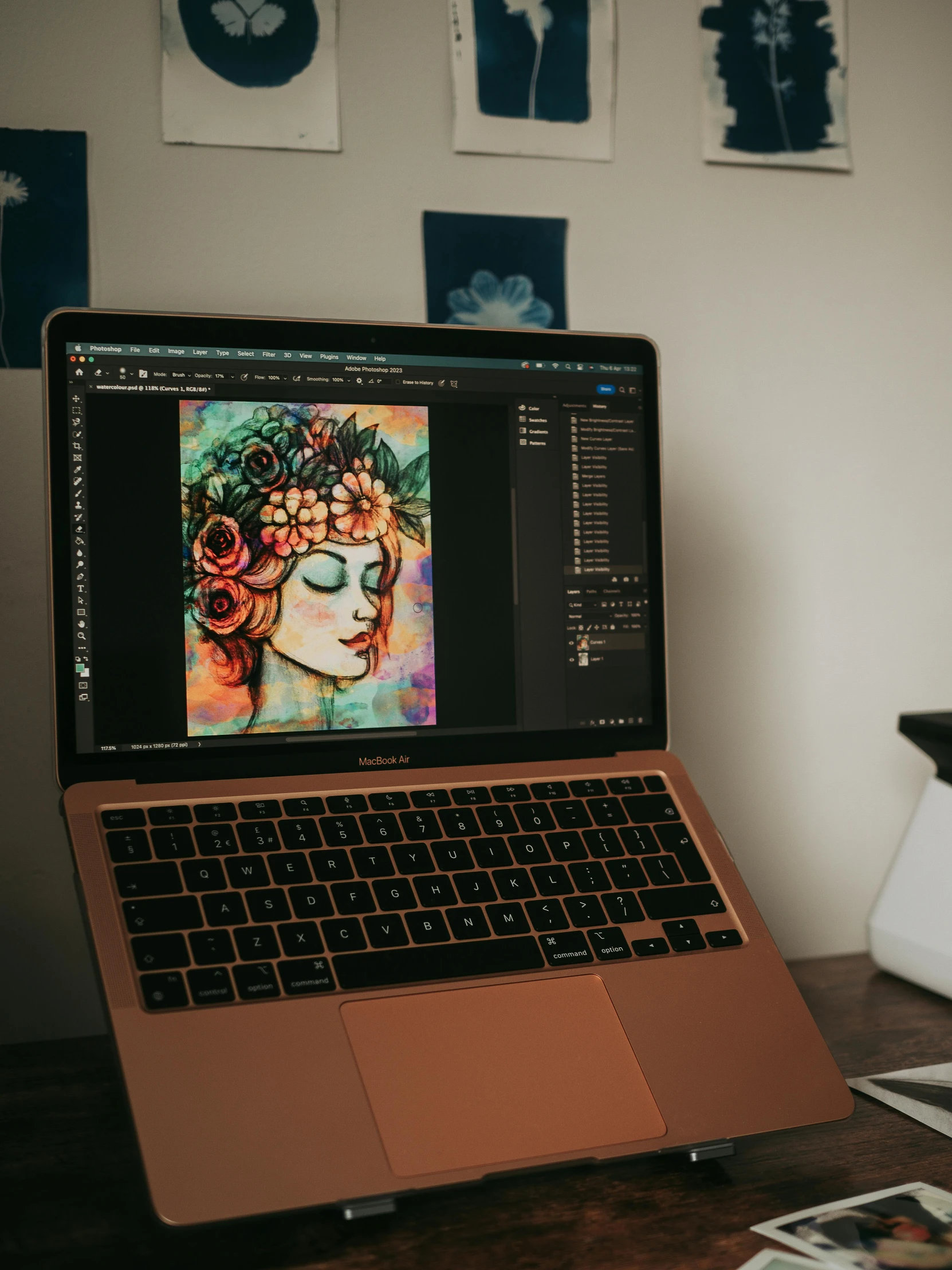 a laptop with a painting on the screen is sitting on a wooden desk