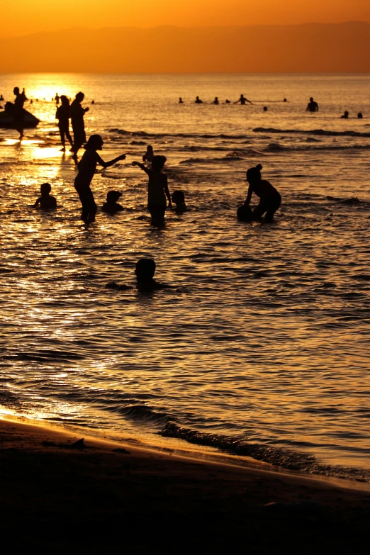 silhouettes of people on a beach at sunset