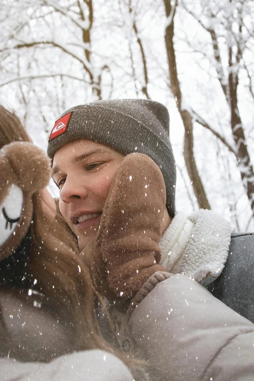 a woman wearing a hat and holding her hand out in the snow