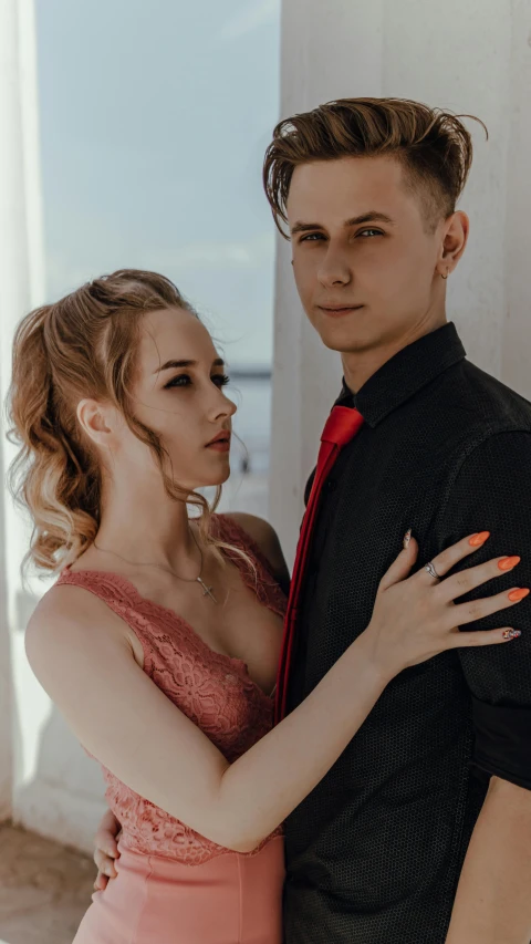 a girl and a guy pose for a po in front of an open door