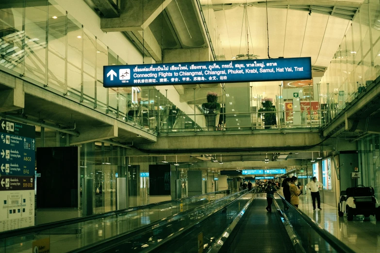 two people walk in an airport with signs above them