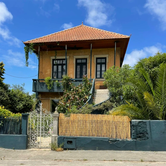 the house is sitting near the lush palm trees