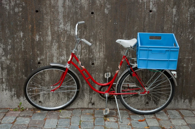 a red bike parked up against a cement wall