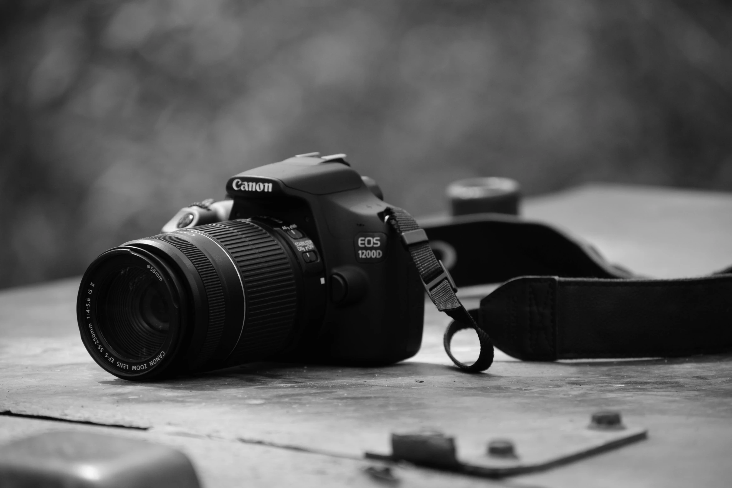 a camera with a strap is sitting on the ground