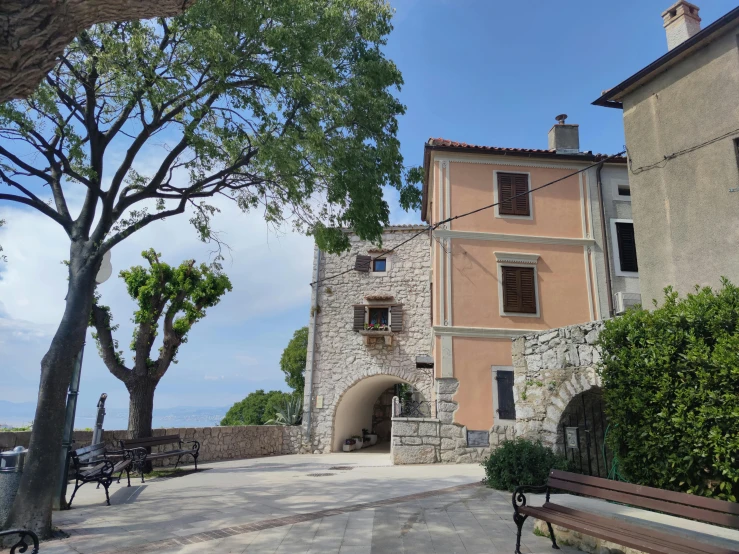 two buildings with several benches and trees outside