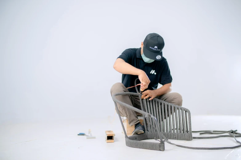 a person kneeling down next to a piece of wire