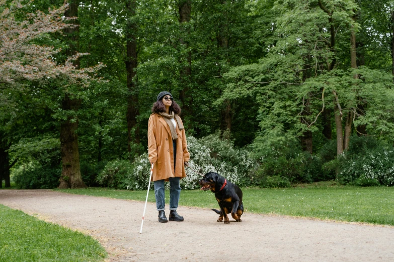 a woman is standing outside with her dogs on a leash