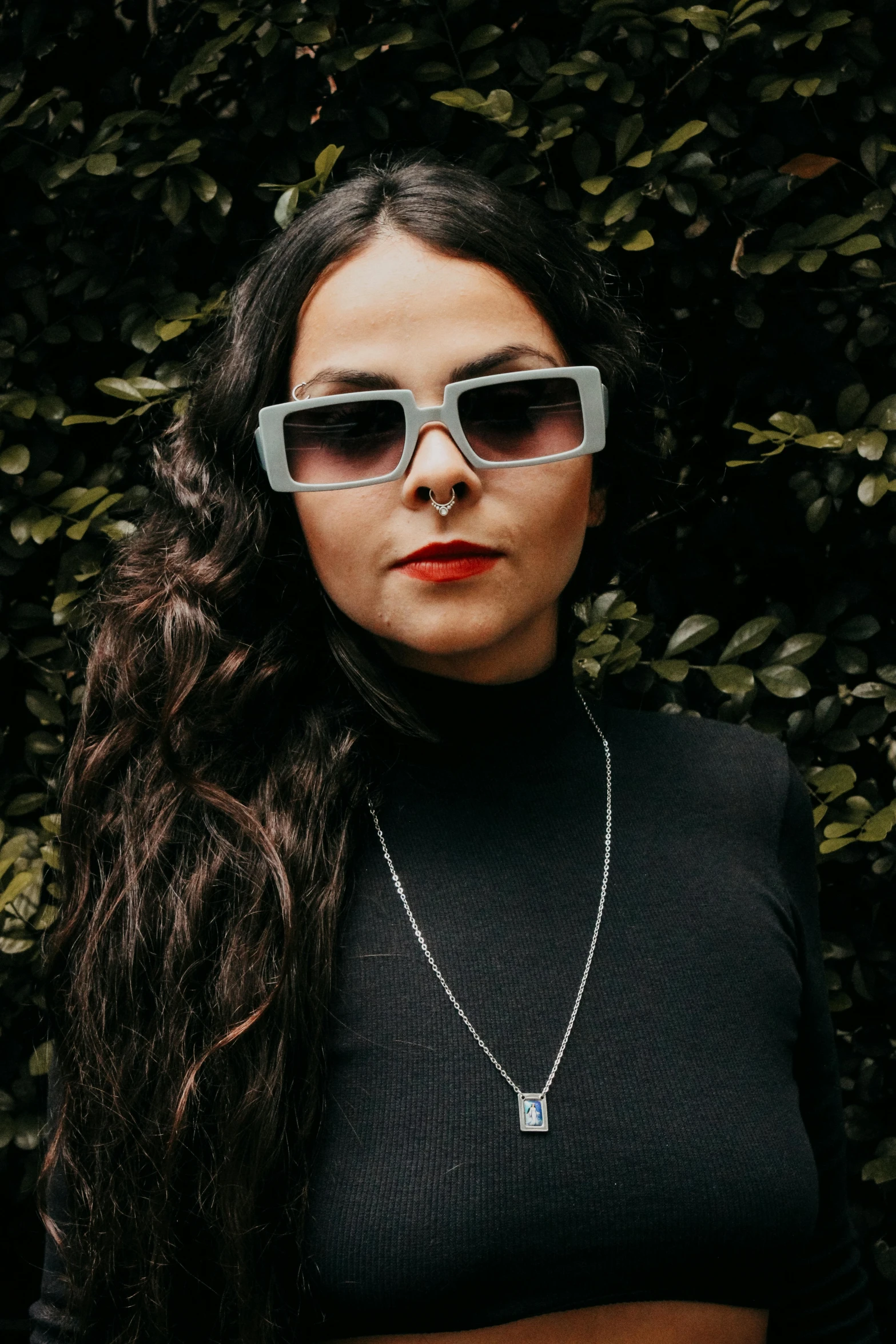 woman with long brown hair wearing glasses looking at the camera