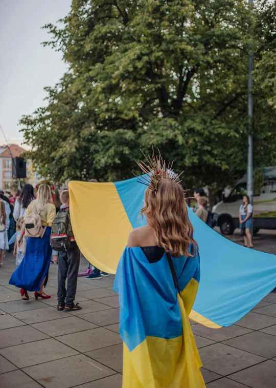 a person holding a flag and other people walking by in the street