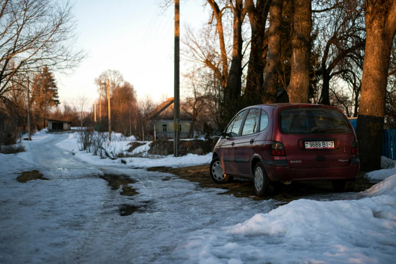 the car is parked on the side of the snow covered road