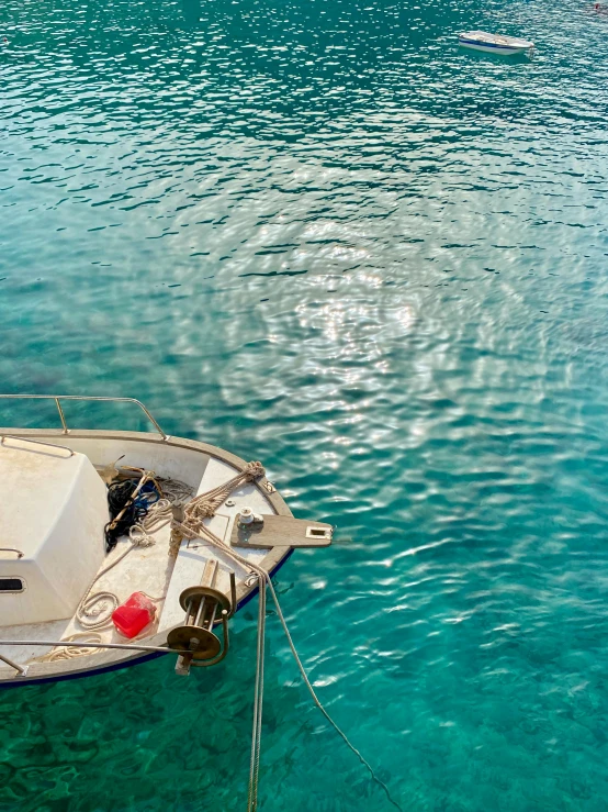 a boat in clear blue water with an island in the distance