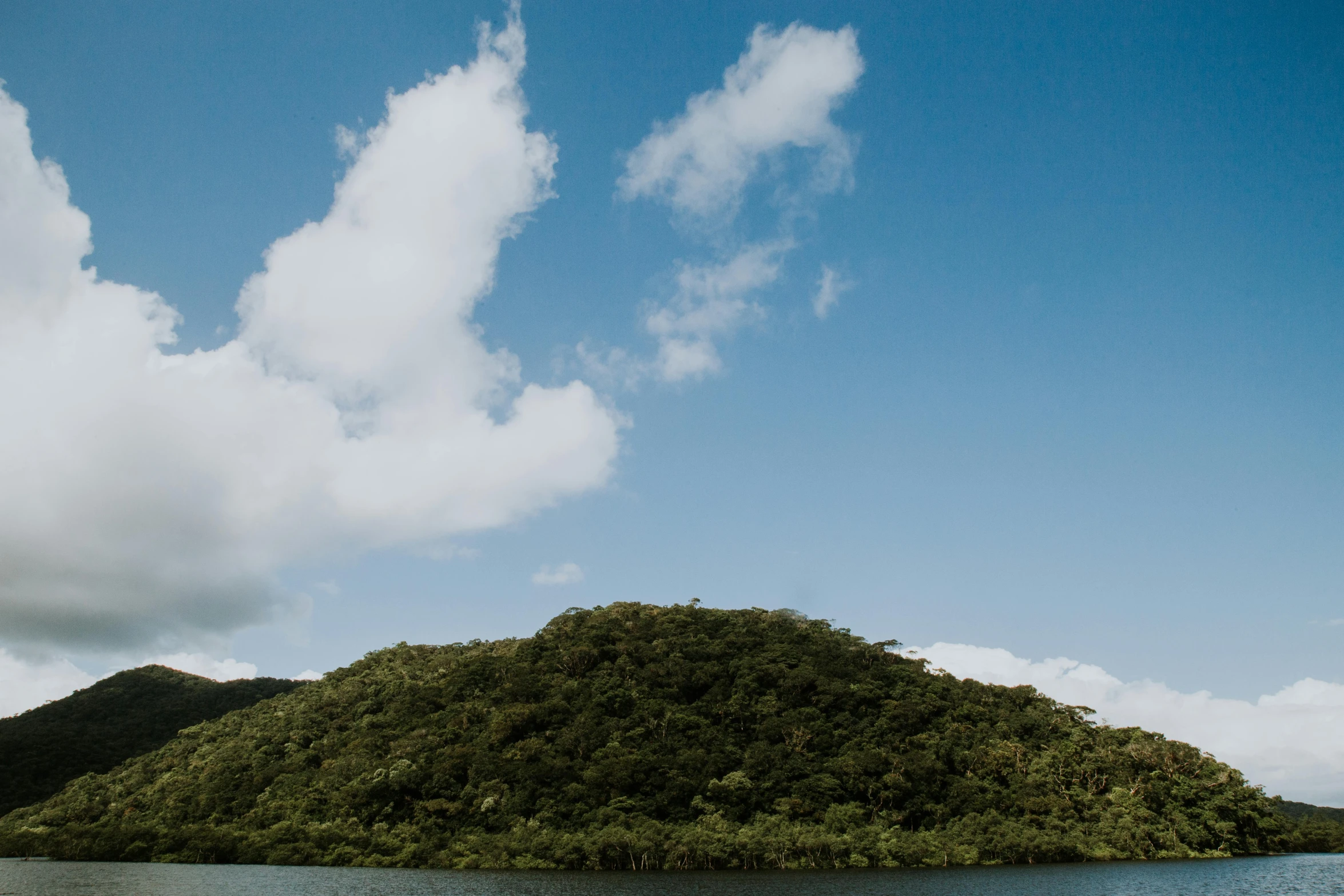 a green hill with a small island in the background