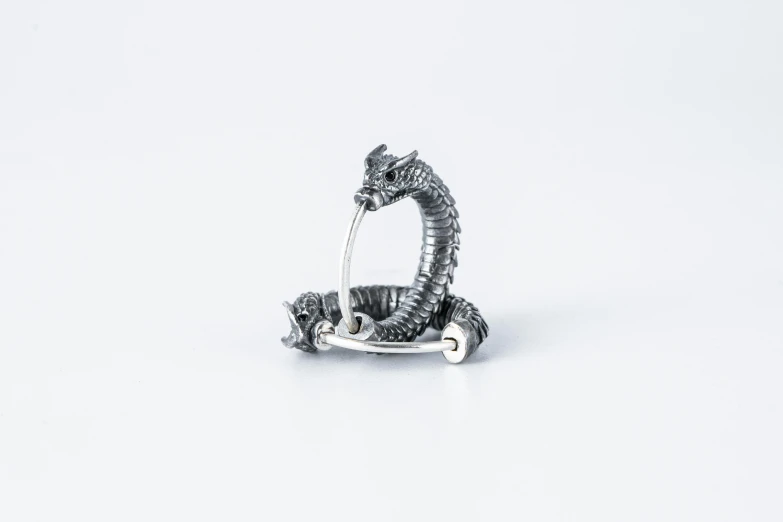 small silver figurine of a gator on an iron wheel