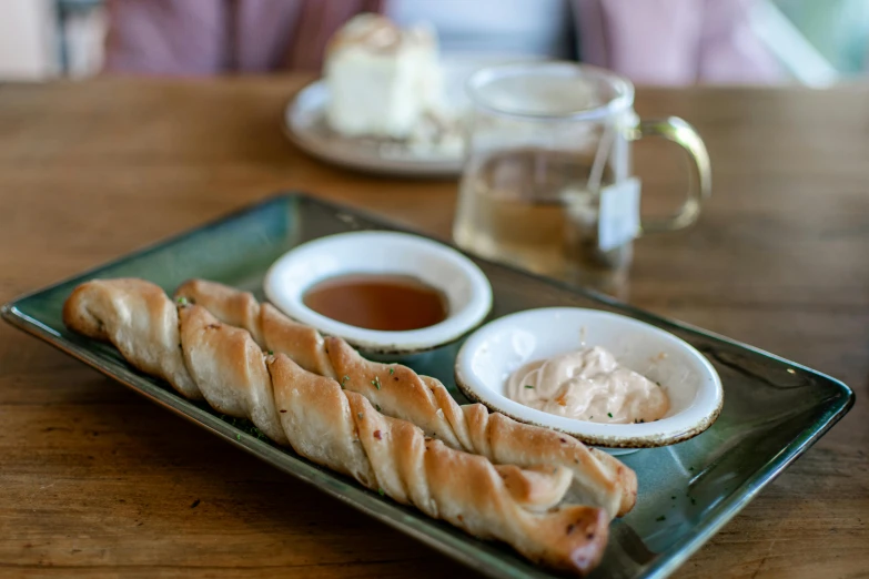 a couple of bread sticks sitting on a plate with dipping sauce