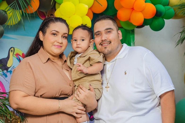 a man standing next to his wife holding a baby