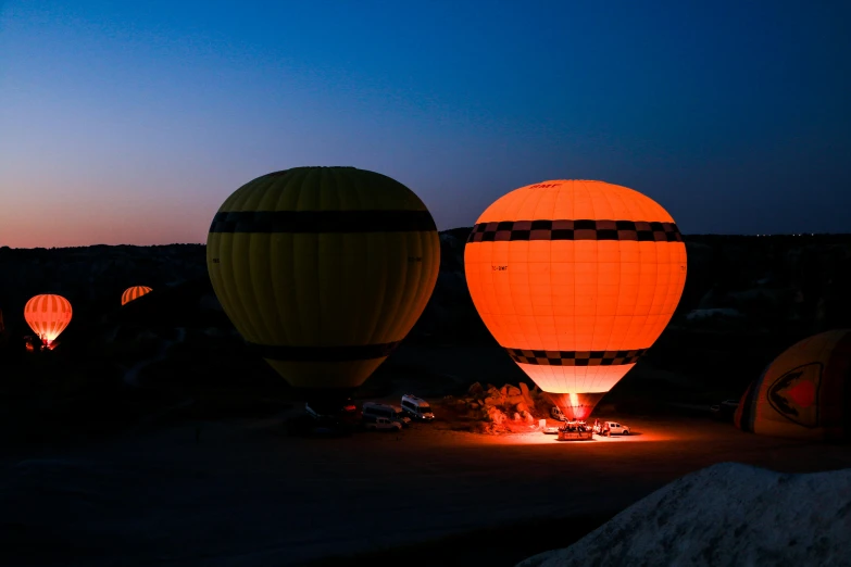 three  air balloons glowing over a sandy beach