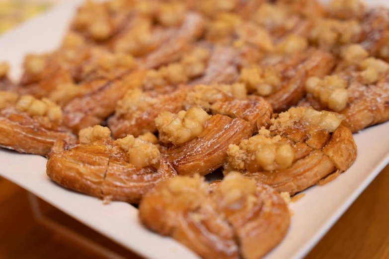 many pastry items sit on a plate on a table