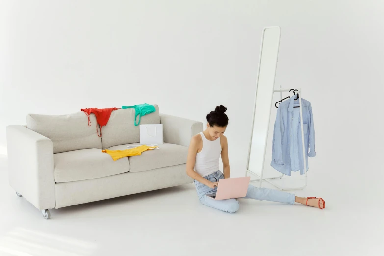 a young lady sitting on the ground in front of a mirror