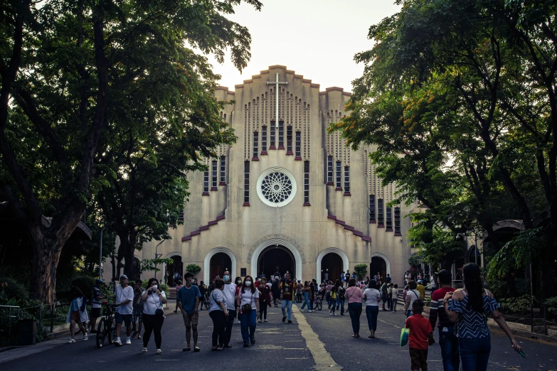 group of people standing around in front of an old church