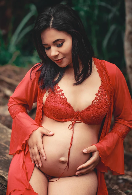 a young pregnant girl is seen in a red underwear