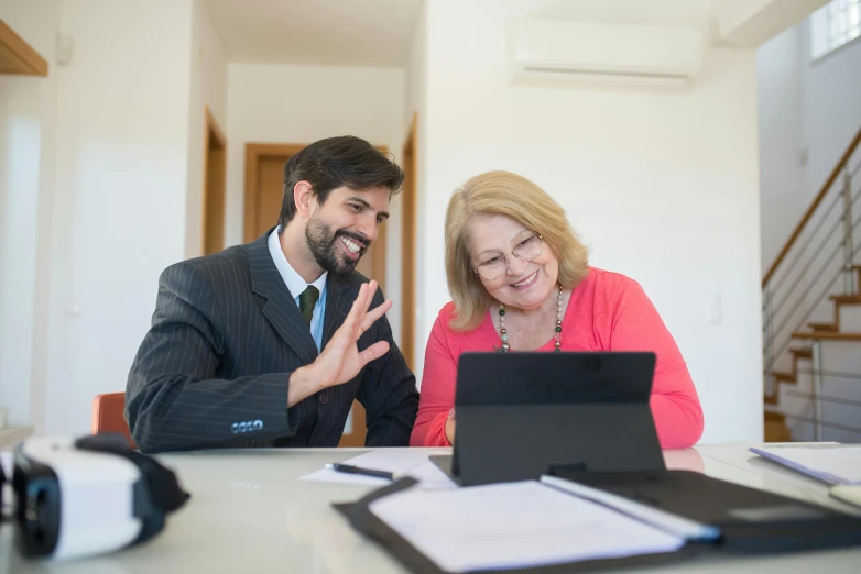 a man and woman in front of a laptop on a table