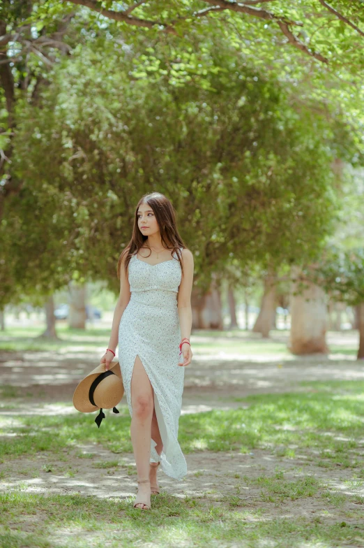 a woman stands in the shade while wearing a white dress