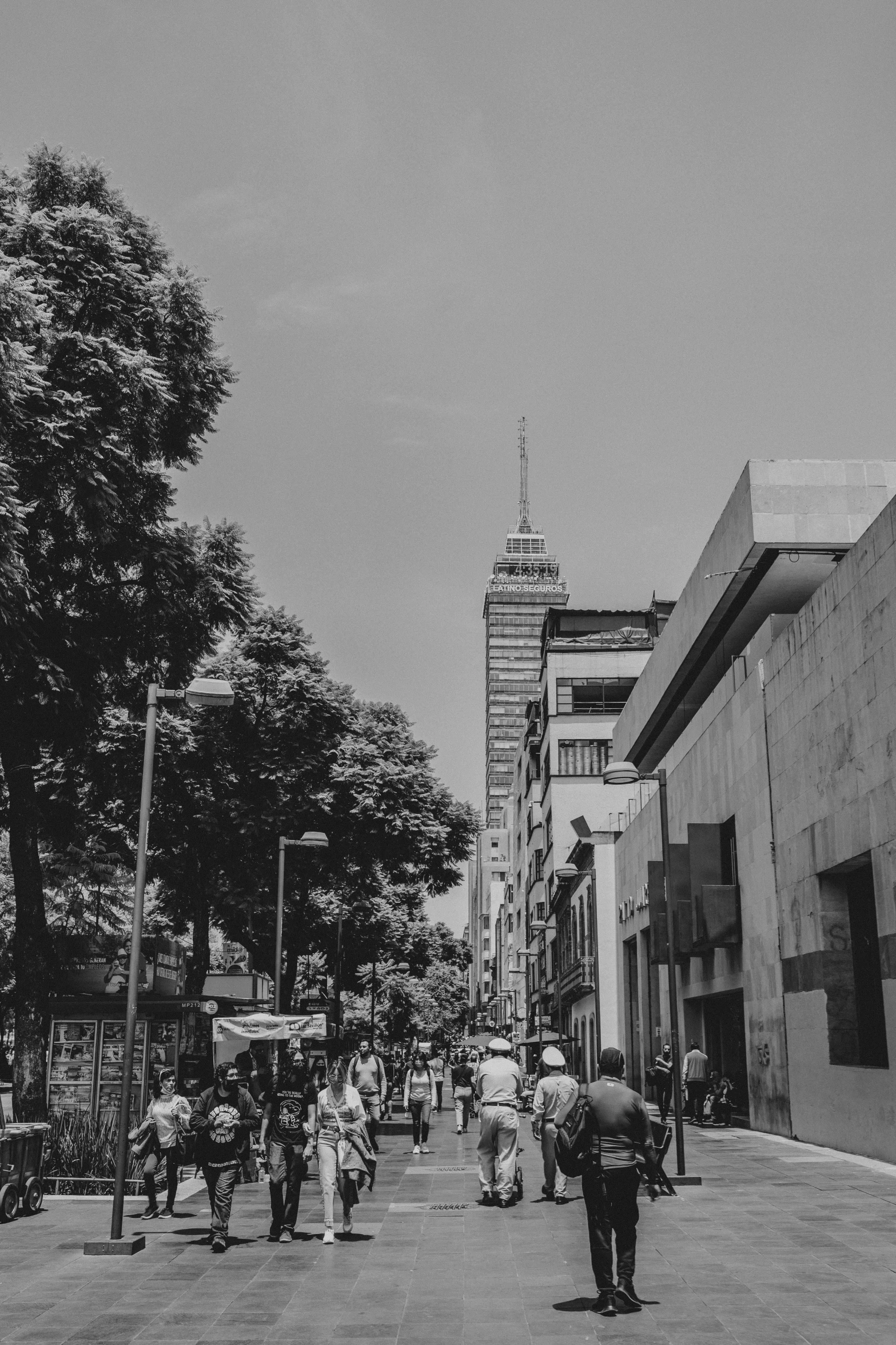 a black and white image of pedestrians walking down the street