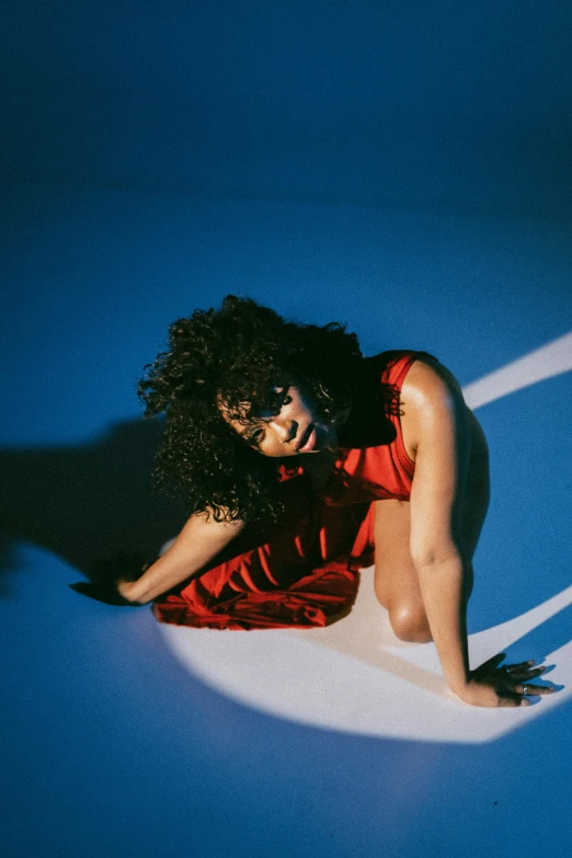 woman lying on blue carpet in a dress