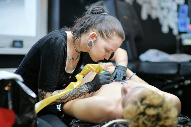 a woman being tattooed is on a table