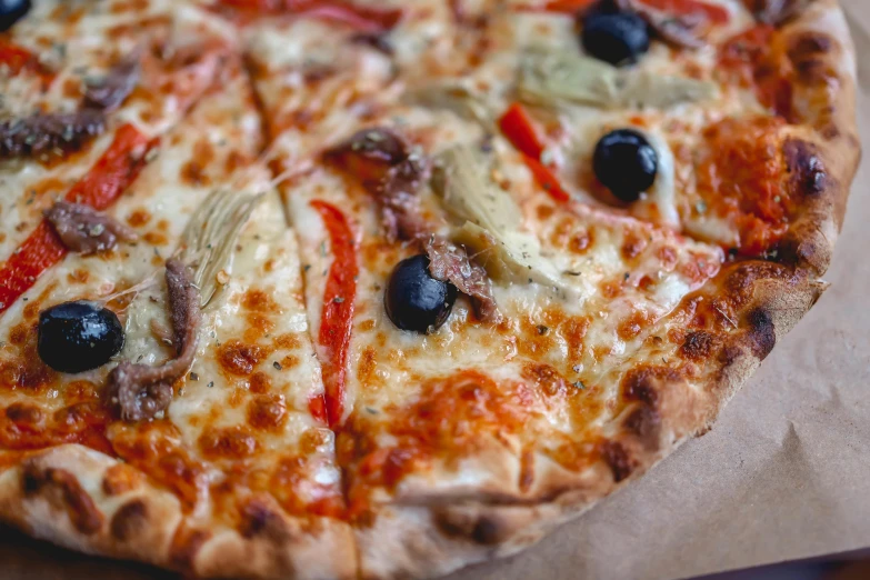 this pizza is served with olives, peppers and sausage