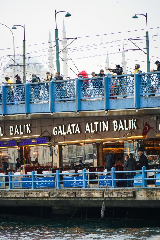 people sitting and eating at the restaurant along the river