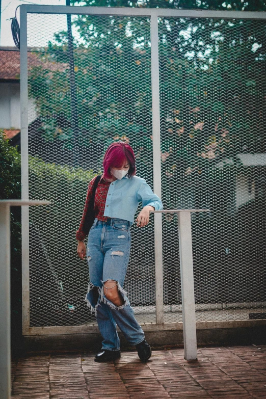 a woman is standing next to a metal fence