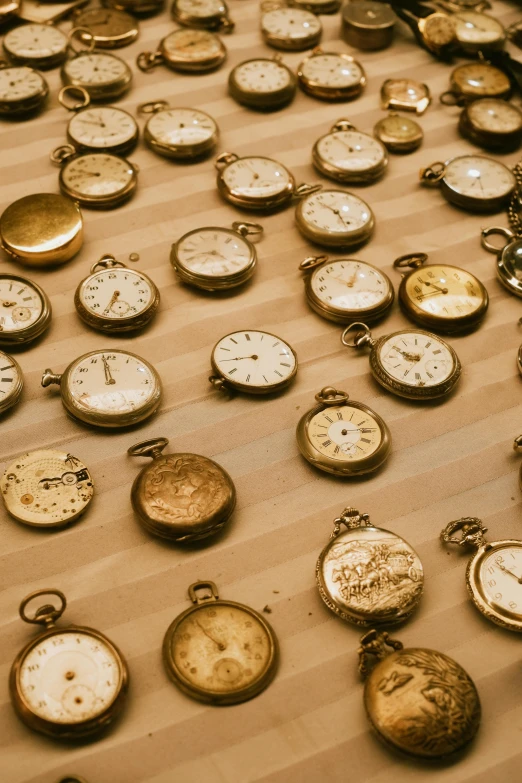 the collection of old pocket watches is laid out on a table