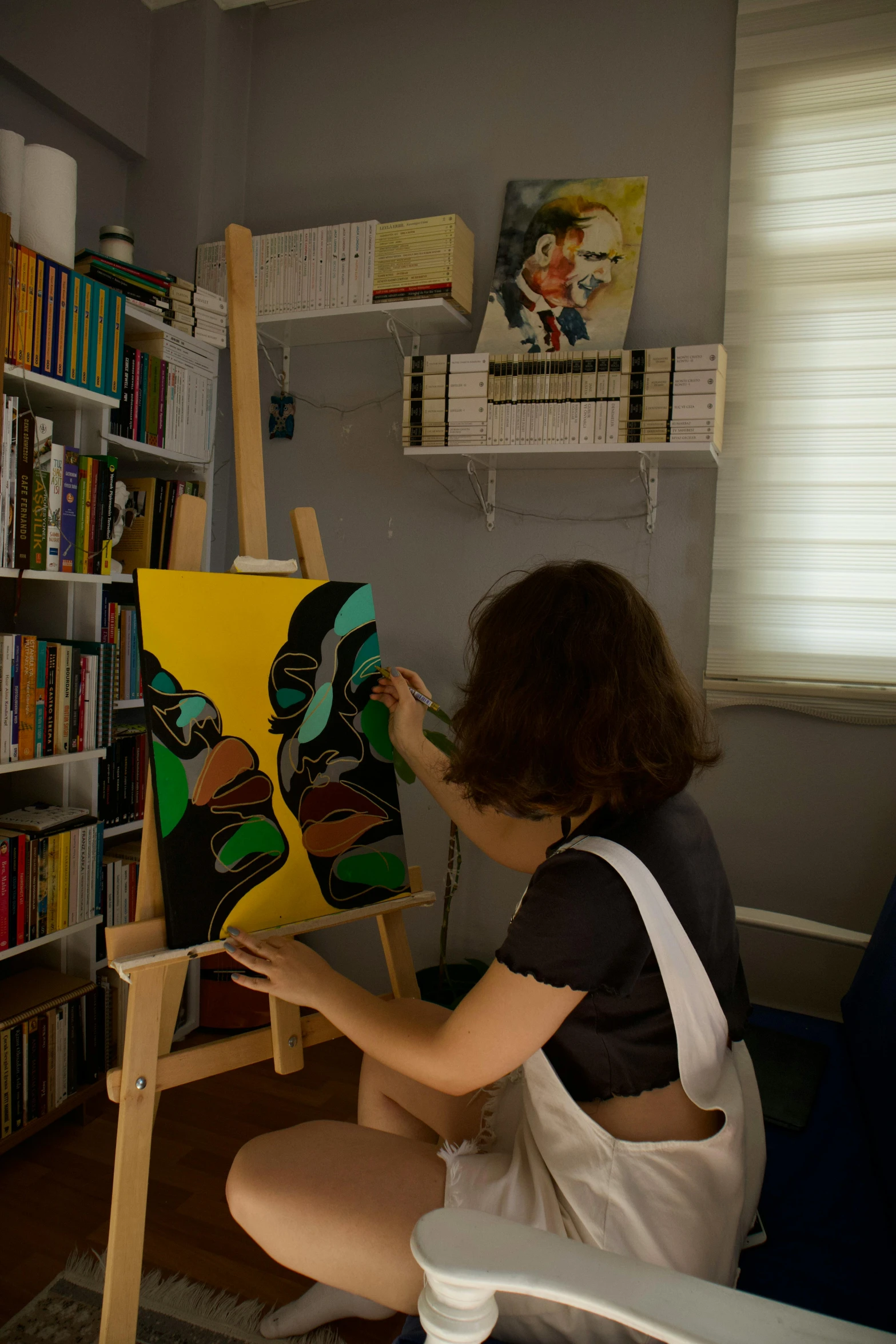 a woman holding a painting while working on it