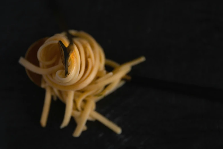 a close - up of some noodles being eaten by someone