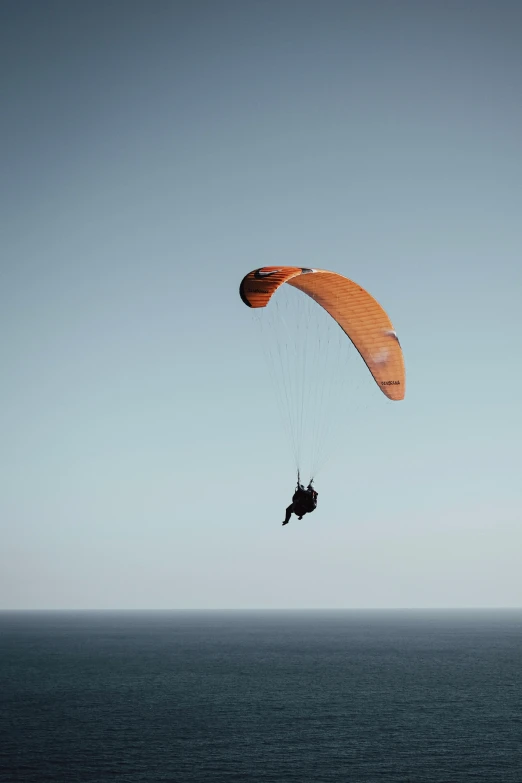 two people are parasailing over a large body of water