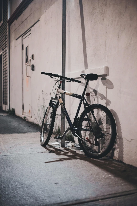 a bicycle parked next to a building with graffiti on it