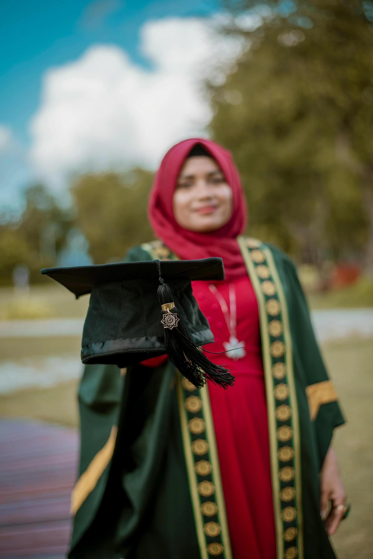 the woman is dressed in her graduation robe and is holding her cap and gown