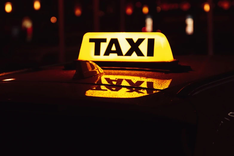 a yellow taxi sign on top of a black car