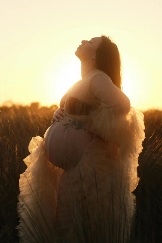 the silhouette of a pregnant woman with long blonde hair
