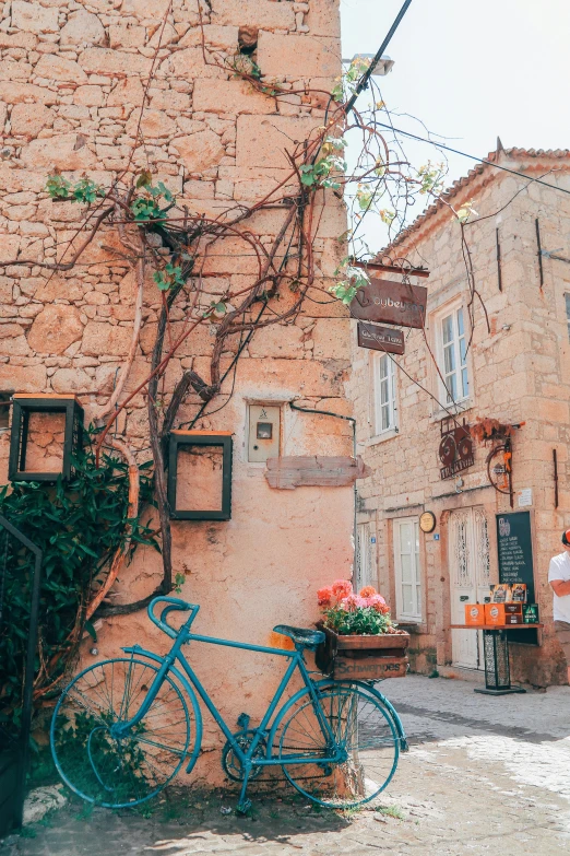 a blue bicycle parked against a brick wall