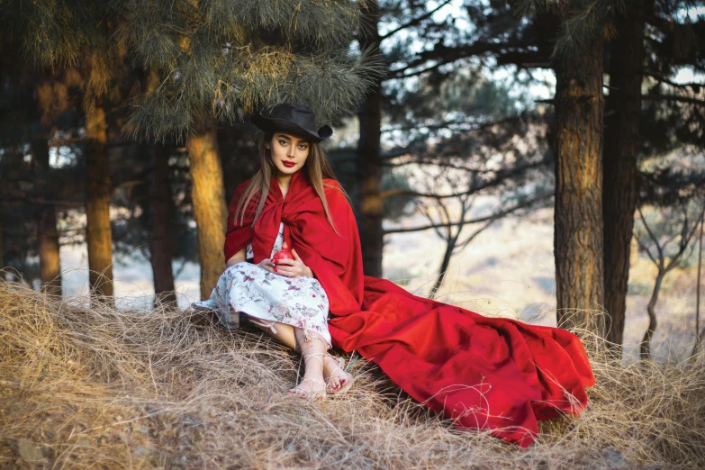 the girl is wearing a red robe and hat