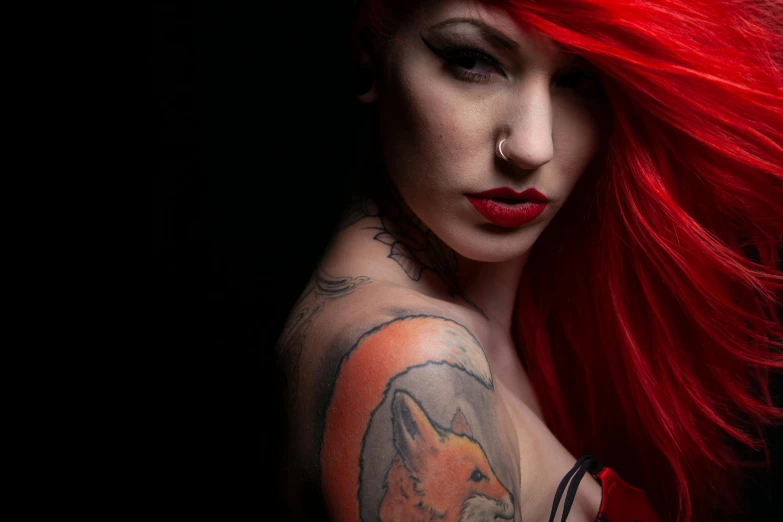 a woman with long red hair has a fox tattoo on her arm