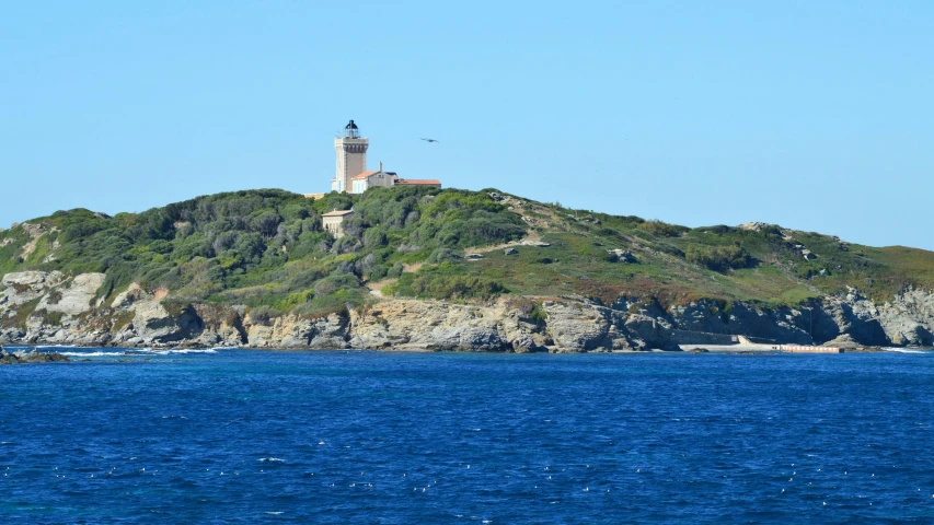 a lighthouse on top of a grassy mountain