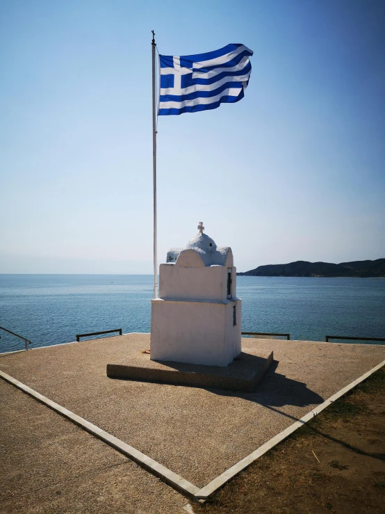 a flag with two birds on it flying over an ocean