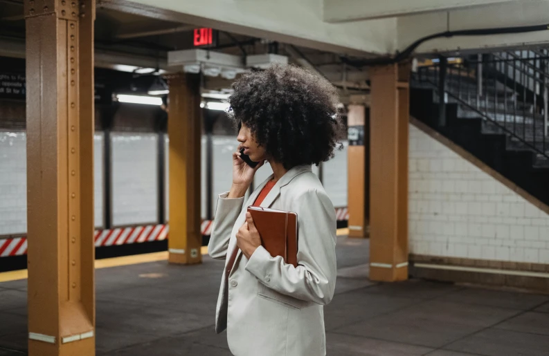 the woman is standing alone on the phone at the station