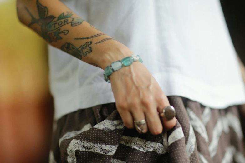 a close up of a person's arm with tattoos holding soing