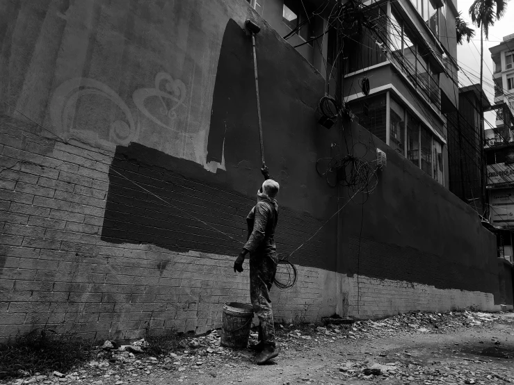 the person is spray painting the side of a building