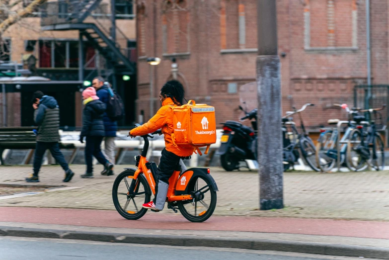 a  in orange riding an orange bike