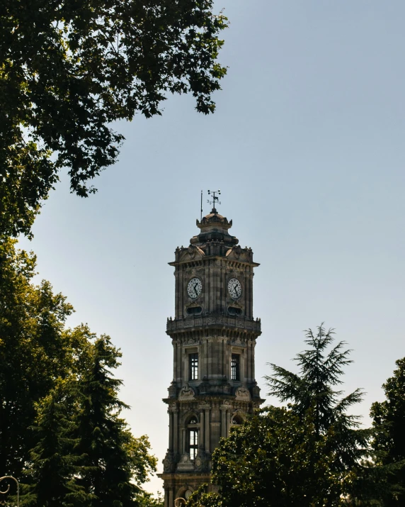 an old clock tower with trees in front of it